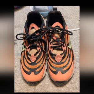 Nike Air Max Torch sneakers featuring a coral orange mesh upper with black wave
